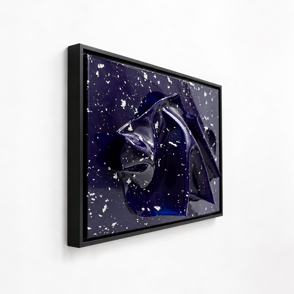 Midnight frame abstract art print featuring a glossy dark blue and black form against a deep navy background with white speckles, shown in a black frame on a white wall.